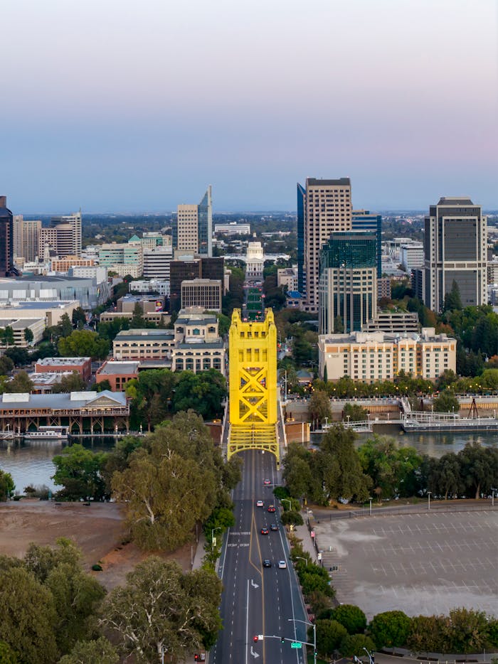 Stunning aerial view of the iconic Tower Bridge in Sacramento, California, surrounded by city skyline at twilight.