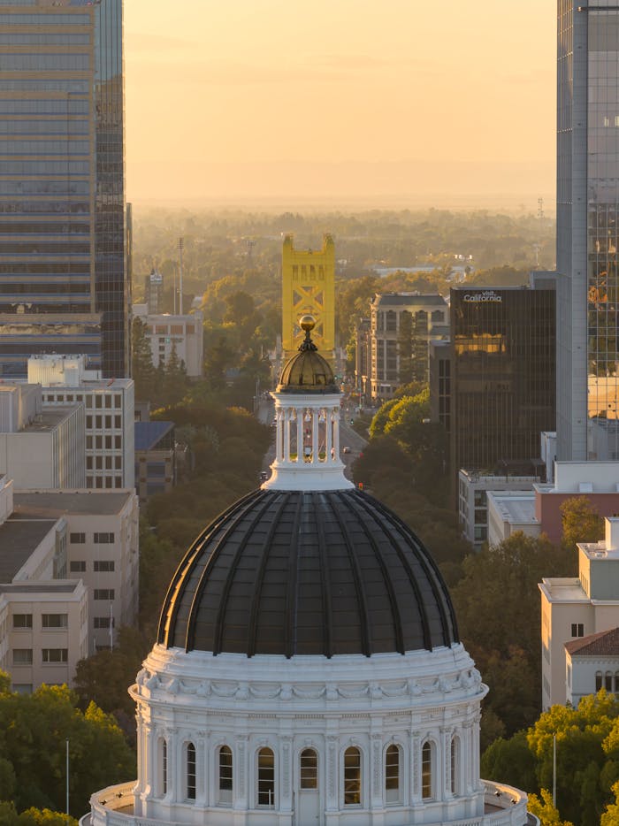 Aerial view of Sacramento with Capitol Dome and Tower Bridge at sunset.