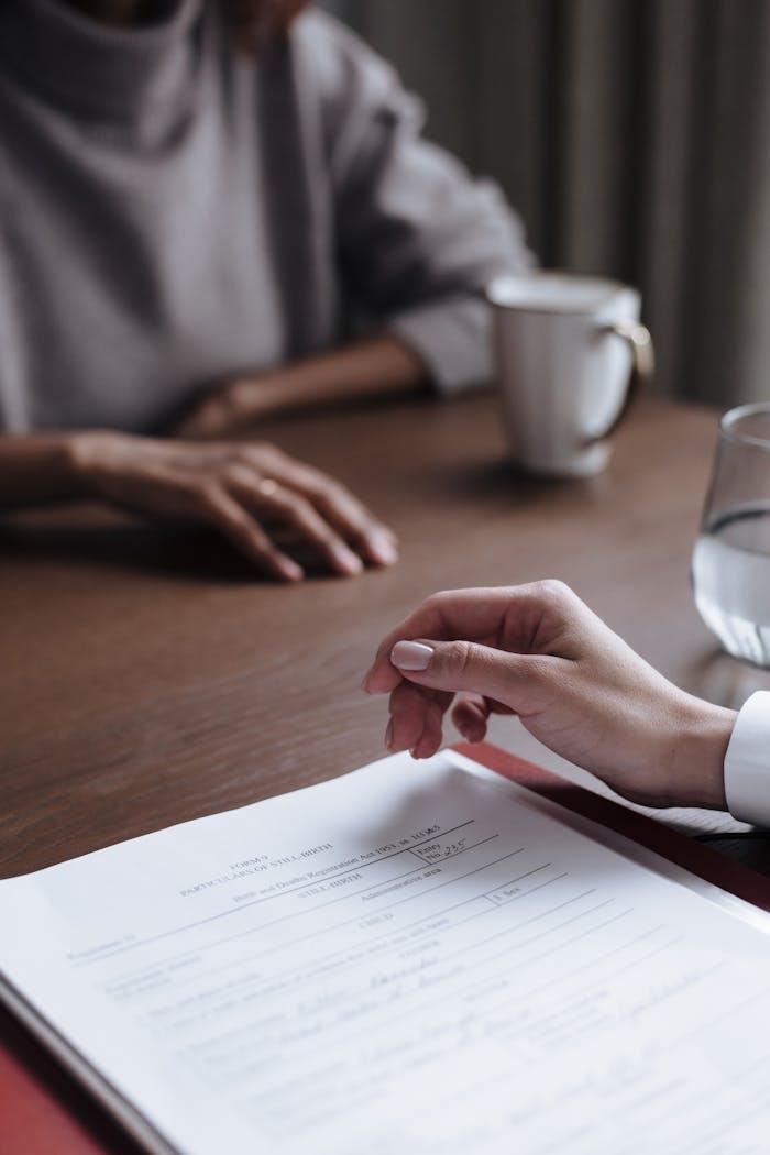 Two people in a business meeting reviewing and signing a contract.